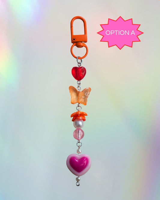 Colorful keychain with heart and butterfly charms in the colors of the Lesbian flag