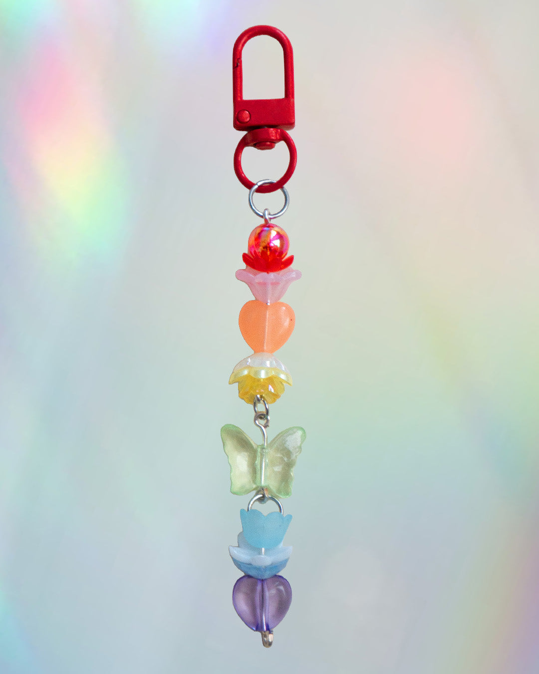 Colorful keychain with rainbow colored beads on an iridescent gradient background