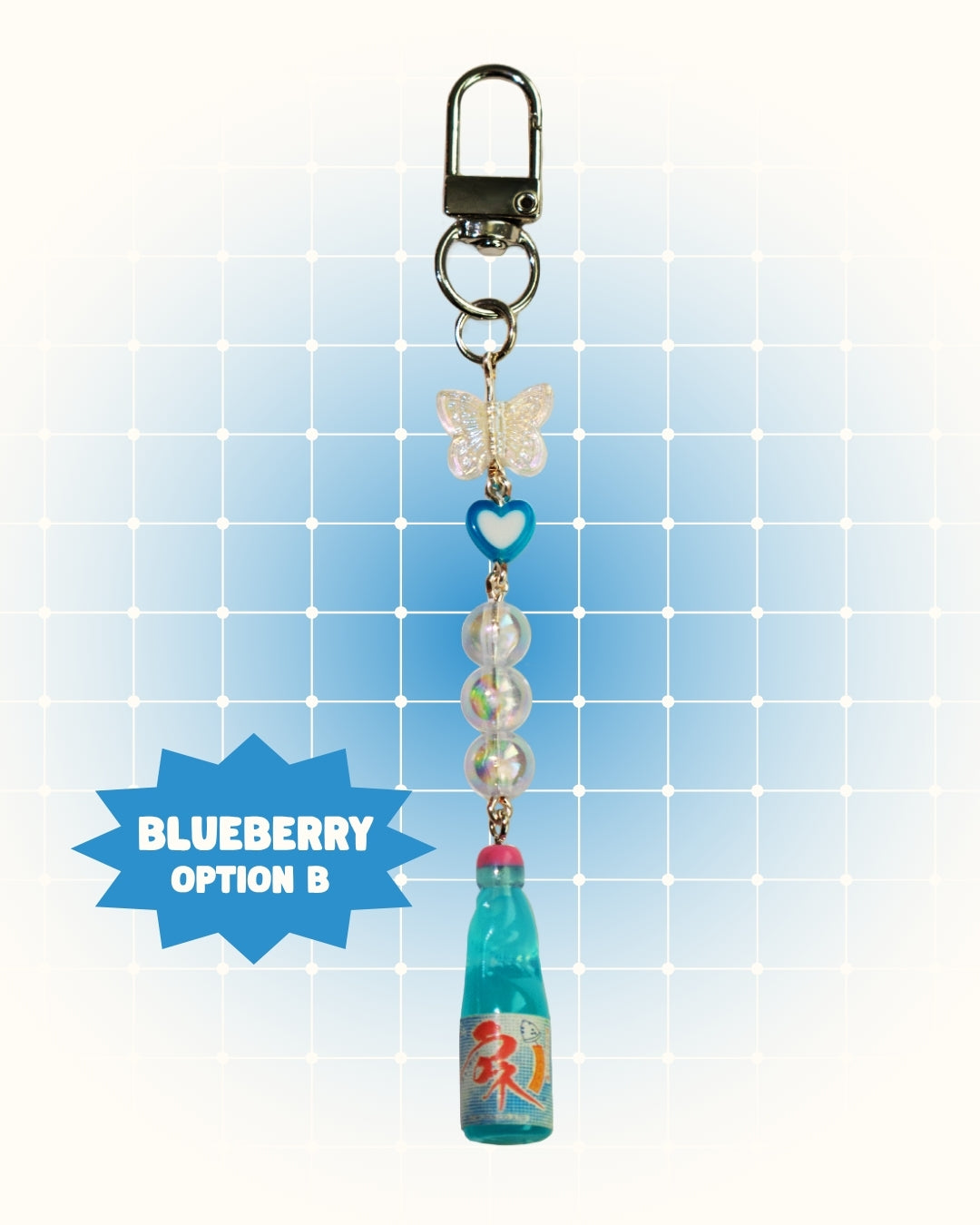 Colorful keychain with blueberry flavor soda on a light blue grid background