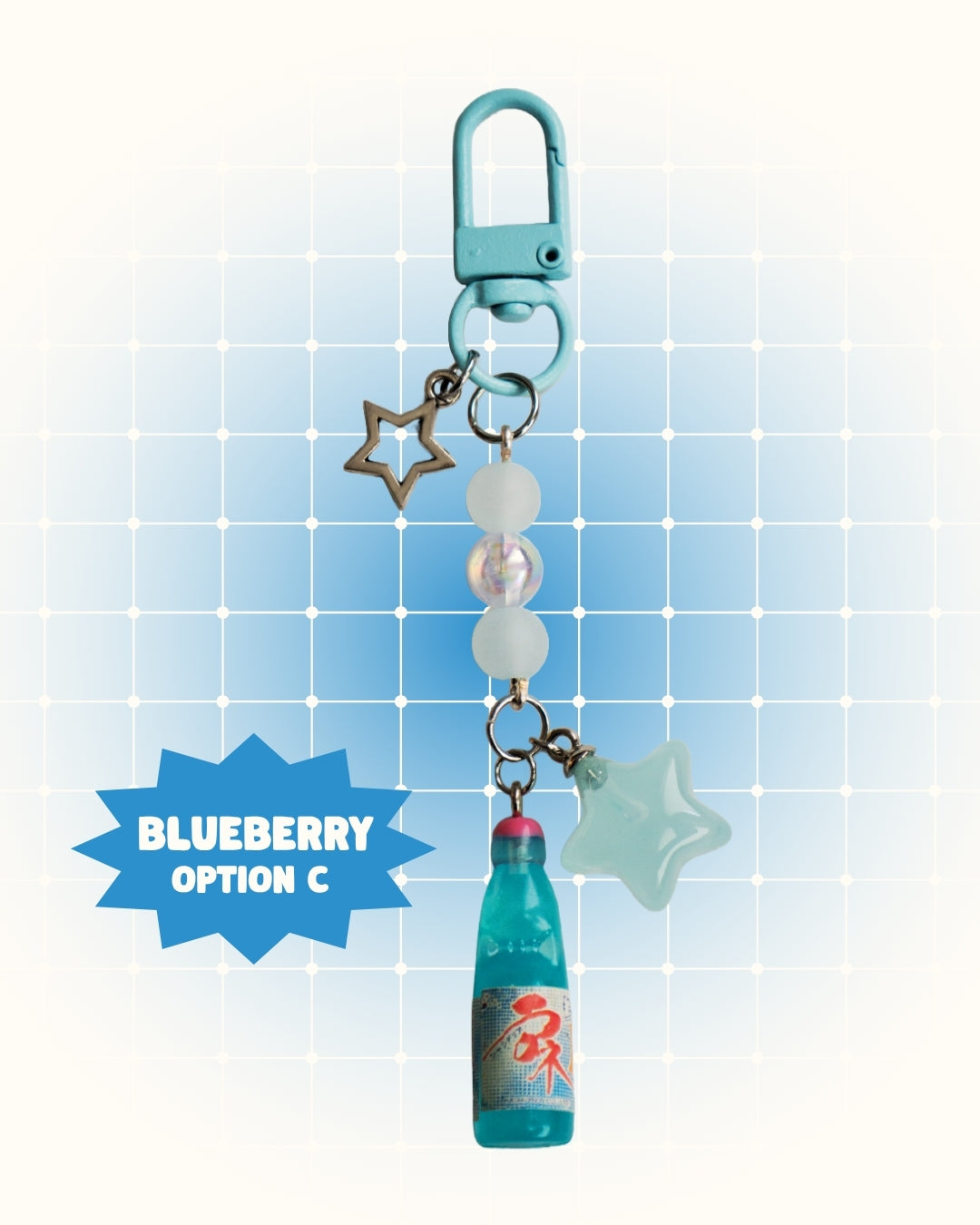 Colorful keychain with blueberry flavor soda on a light blue grid background