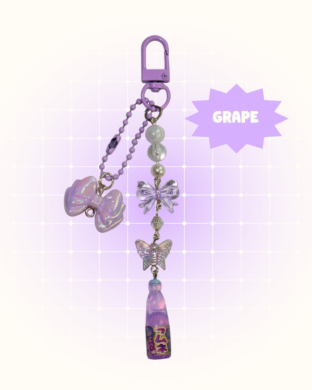 Purple grape soda keychain with decorative elements on a light purple background