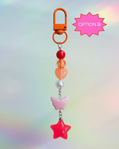 Colorful keychain with star, heart, and butterfly charms in the colors of the Lesbian flag