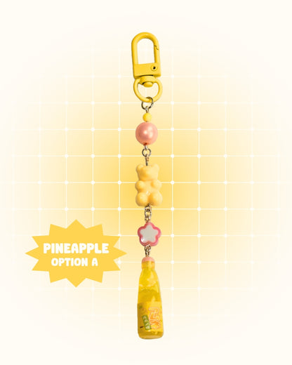 Colorful keychain with pineapple soda design on a yellow gradient background