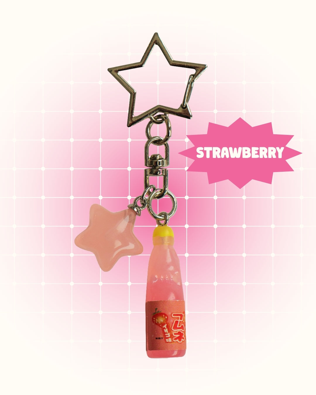 Keychain with star-shaped charm and strawberry soda charm on a pink gradient background